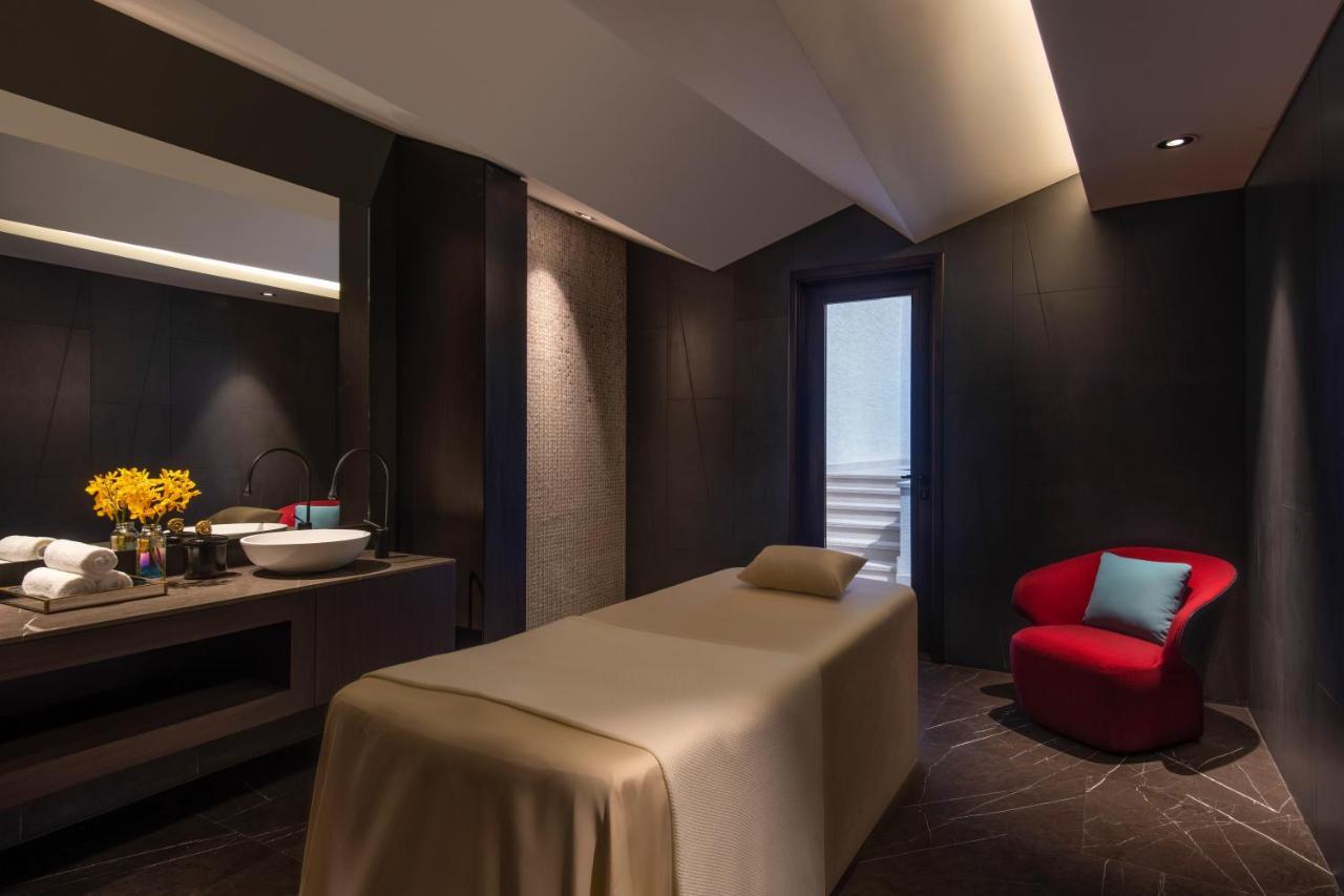 Steigenberger Hotel Доха Екстер'єр фото The photo shows a serene spa room designed for relaxation and treatments. It features a massage table covered in a neutral-colored fabric, positioned centrally in the room. On one side, there is a sleek vanity area with a sink, where a small vase of 